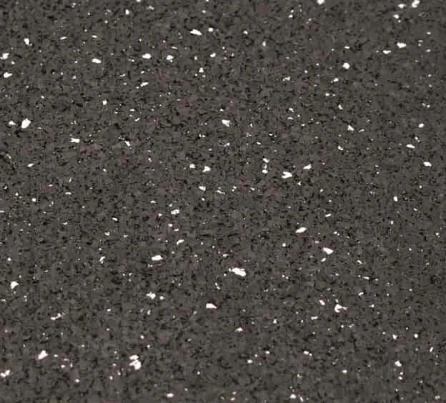 Close-up of a resilient black rubber flooring surface with multicolored EPDM granules for gym use.