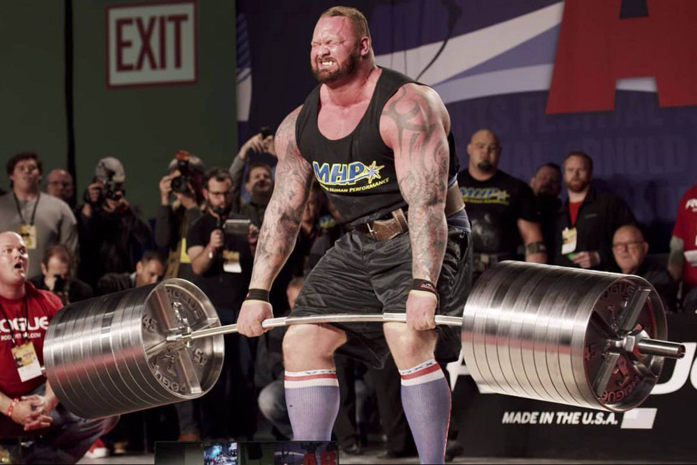 StrongArm Elephant Bar in use at a strongman competition, showcasing heavy deadlifts with premium gym gear.
