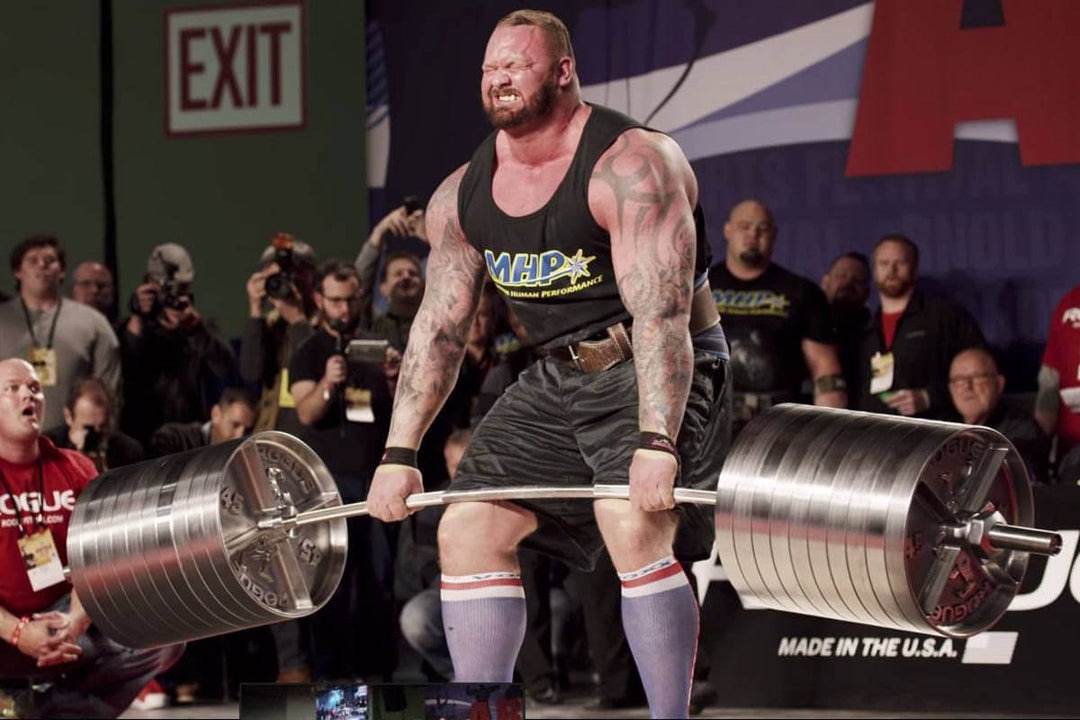 StrongArm Elephant Bar in use at a strongman competition, showcasing heavy deadlifts with premium gym gear.