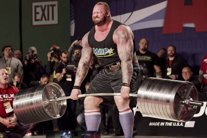 StrongArm Elephant Bar in use at a strongman competition, showcasing heavy deadlifts with premium gym gear.